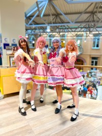 Vier vrouwen in roze cosplay in de bibliotheek in Roosendaal